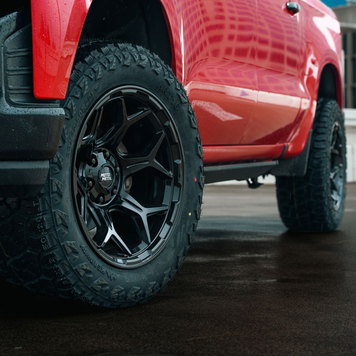 red truck with black tires and rims